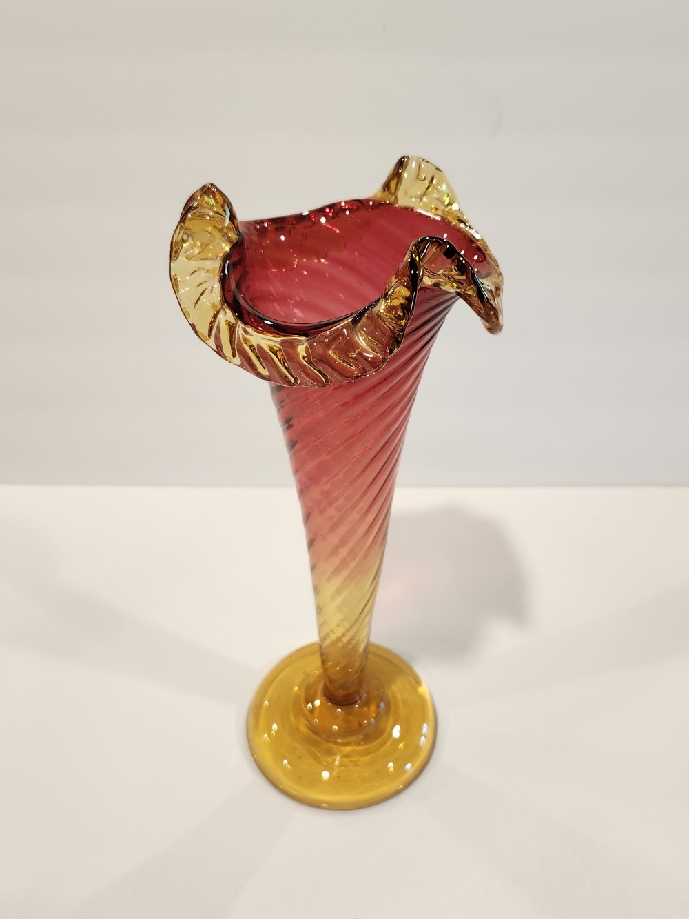 Vintage cranberry amberina trumpet vase with ruffled rim and swirl pattern